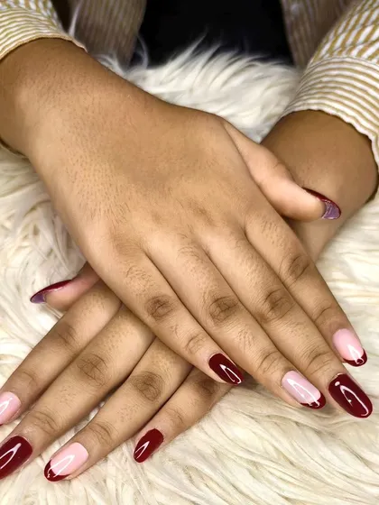 A modern take on a classic, these almond-shaped nails feature a sheer pink base with bold, deep red French tips. This design offers a sophisticated yet contemporary look for any occasion.