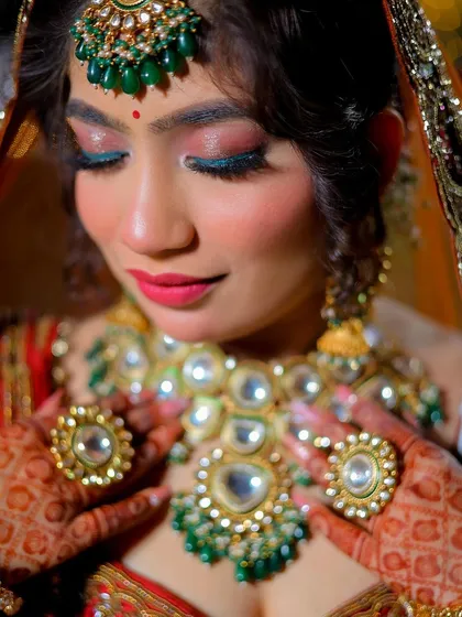A detailed close-up of the bride's hands framing her necklace, showcasing the jewelry and henna.