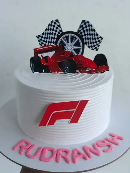 For the racing enthusiast, a custom F1 themed cake. This design features the iconic F1 logo, a race car, and checkered flags, making it the perfect centerpiece for a fan's birthday party.