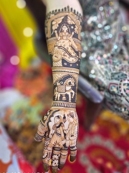 This design tells a story up the arm, with a couple portrait on the hand, a royal horse figure, and a beautiful bride in a jharokha window. The use of negative space makes the figures stand out.