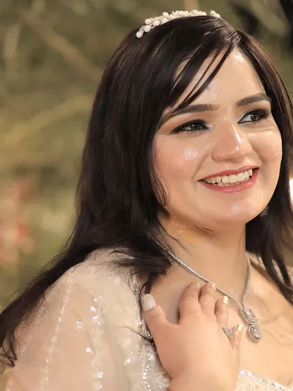 A close-up of the bride's happy, smiling face, showing how the makeup enhances her natural joy.