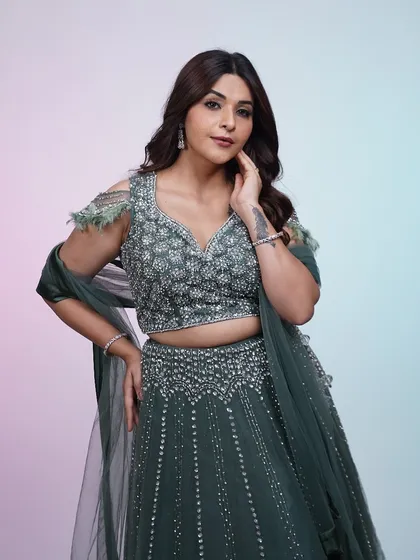 This dark green lehenga is perfect for a wedding reception or cocktail party, with its sparkling details and flattering A-line cut.