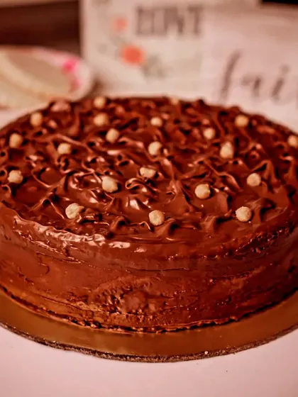 A different angle of our Nutella Hazelnut Cake, showing the swirls of rich frosting and scattered nuts. It's as delicious as it looks.
