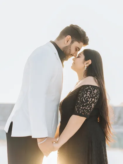 An intimate, sunlit portrait where the couple is touching foreheads, creating a feeling of deep connection and romance.