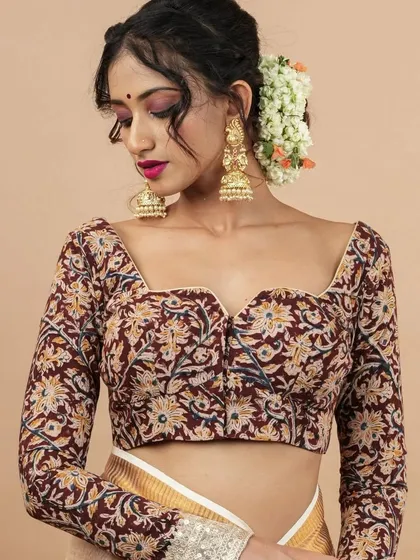 A perfect example of how jewellery can be the centerpiece of an outfit. Here, the model showcases a pair of oversized, handcrafted jhumkas with a beautiful floral design and full-bodied structure. Paired with a Kalamkari print blouse, this look balances traditional motifs with contemporary style.