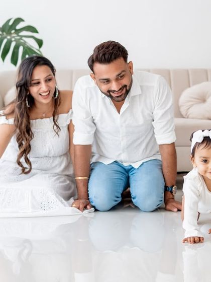 A family portrait with the baby crawling in the foreground.