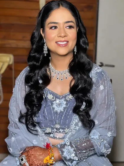 A smiling portrait of Khushi. The makeup is fresh and youthful, perfect for a sangeet celebration.