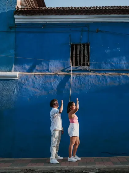 A fun and quirky shot of a couple posing against a vibrant blue wall in Goa. We love finding colorful and unique spots that add a creative touch to your pre-wedding album.