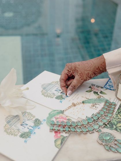 A detail shot of the wedding stationery and the bride's stunning emerald jewelry.
