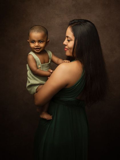 A beautiful moment between mother and child, with the baby smiling at the camera.