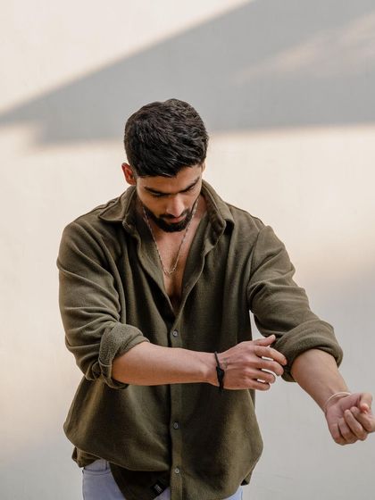 Action shots add dynamism to a portfolio. Here, we captured the simple act of rolling up a sleeve to create a candid, masculine image that tells a story of preparation and effortless style.