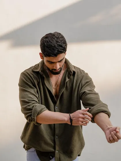 An action shot of the model rolling up his sleeves. These candid-style moments add a natural and dynamic feel to a portfolio, showing the model in a more relaxed state.