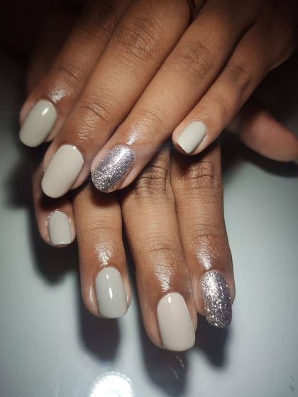 A beautiful, understated look with a greige polish on short, natural nails, complemented by a silver glitter accent nail.