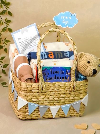 An 'It's a Boy' gift basket with a blue color scheme. The addition of greenery and a personalized card adds a thoughtful, styled touch.