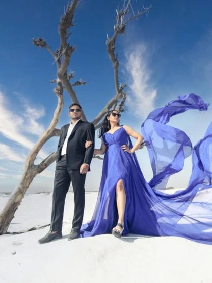 A powerful pose showing off the full effect of the wind-swept royal blue trail gown. This dress is a favorite for couples wanting a high-fashion, editorial look for their shoot.