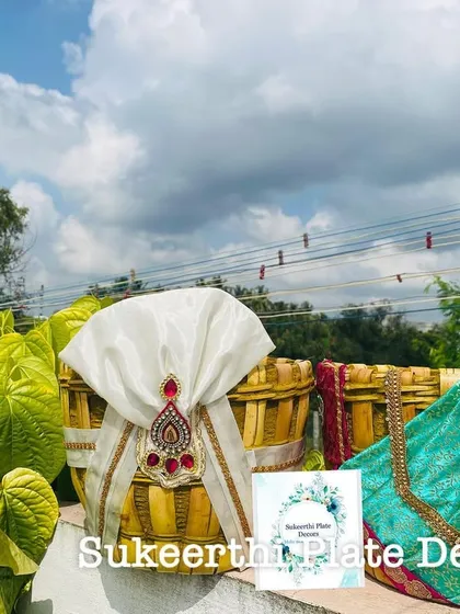 A custom-decorated Uppukudai pair, featuring a beautiful turquoise-green saree design for the bride basket.