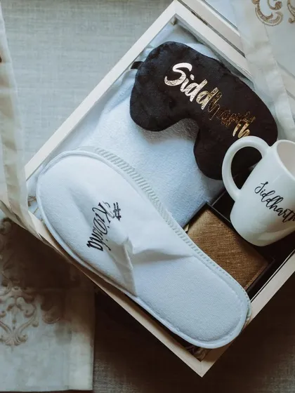 A personalized welcome kit for the wedding party, including custom slippers, a mug, and an eye mask. We believe in taking care of the entire wedding entourage.