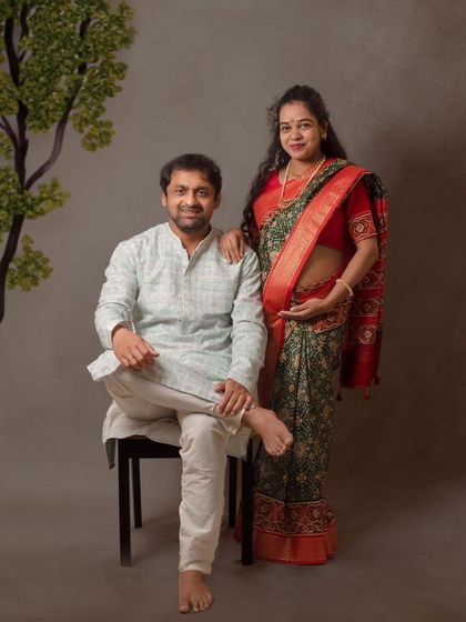 A formal portrait of a couple in traditional attire. This style of maternity photography creates a timeless and dignified family heirloom.