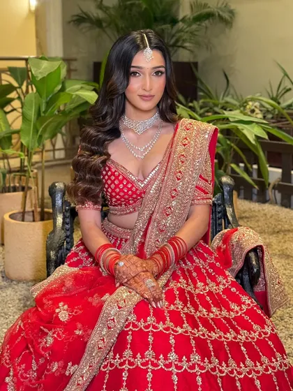 A seated portrait that captures the full splendor of the red lehenga. Her makeup is timeless, with a neutral lip and defined eyes that will look beautiful for years to come.