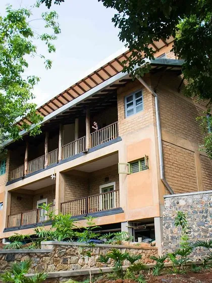 The multi-story residential block at PLENTI House, built with adobe bricks and featuring long verandas for circulation and relaxation.