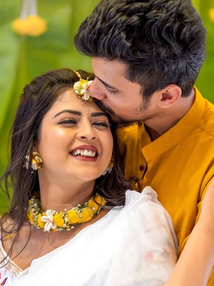 A sweet moment between the couple during their Haldi ceremony. The bride's makeup is light and waterproof to withstand the festivities.