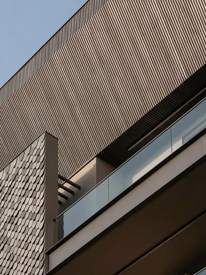 A detail shot from our Gurugram builder floor, showing the texture of the shingles against the clean lines of the aluminum louvers. This contrast creates a visually interesting and modern facade.