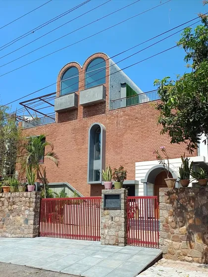 The Brick Vault House in Hyderabad showcases my approach to adaptive reuse. The facade features exposed brick and distinctive arched windows, creating a modern yet timeless look. This project involved adding two new floors to an existing structure while adhering to Vastu principles.