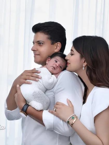 A sweet, candid moment where mom leans in to give her baby a kiss while dad holds them securely. These are the authentic interactions I aim to capture.