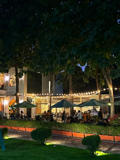As evening falls, the cafe becomes a cozy retreat with warm lighting and a view of the greens.