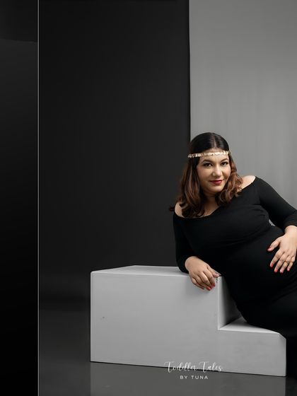 A classic portrait pose with a modern twist. The simple black dress and pearl headpiece create a look that is both vintage-inspired and perfectly contemporary.