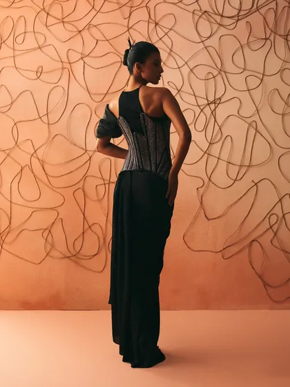 The back of the Nexus gown, where cords trace themselves into memory, tightening across an asymmetric corset over a pre-stitched sari.
