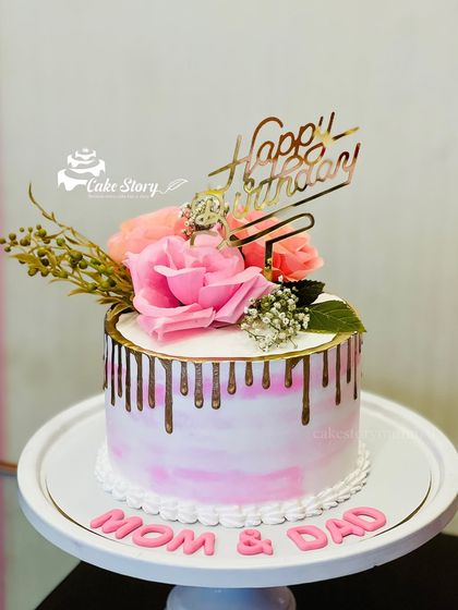 A lovely drip cake for Mom and Dad's combined birthday celebration. The pink marble effect is complemented by a gold drip and fresh flowers.
