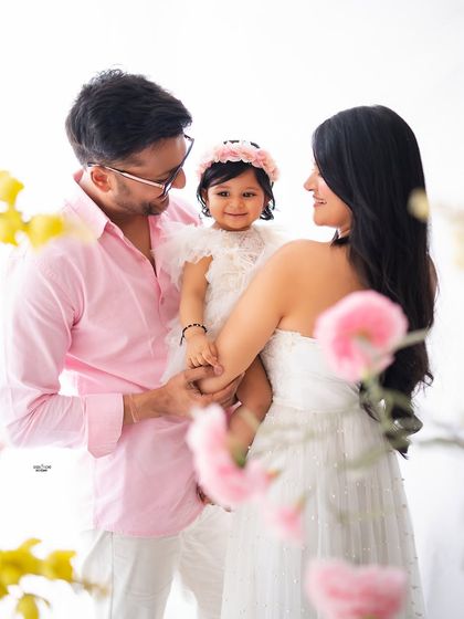 A beautiful family portrait surrounded by soft, dreamy flowers. The pink and white color scheme adds a touch of spring to this lovely moment.