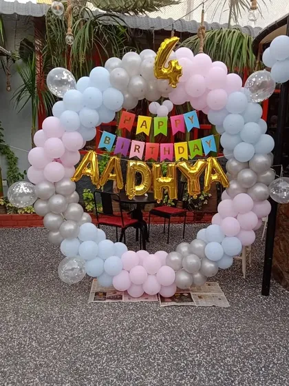 A sweet pastel-themed 4th birthday for Aadhya. This circular balloon arch in pink, blue, and silver is perfect for a cafe or restaurant setting.