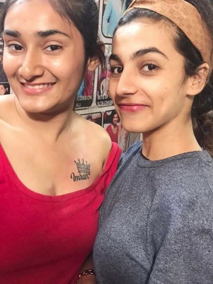 A client with a crown and name tattoo on her chest.