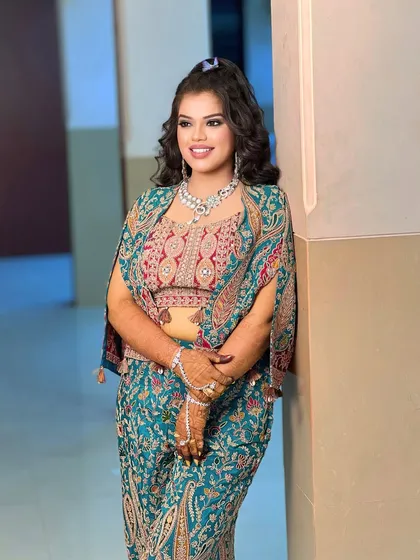 A vibrant look for a Sangeet or DJ night. The model is wearing a colorful printed outfit with a modern diamond and pearl necklace that is both fun and elegant.
