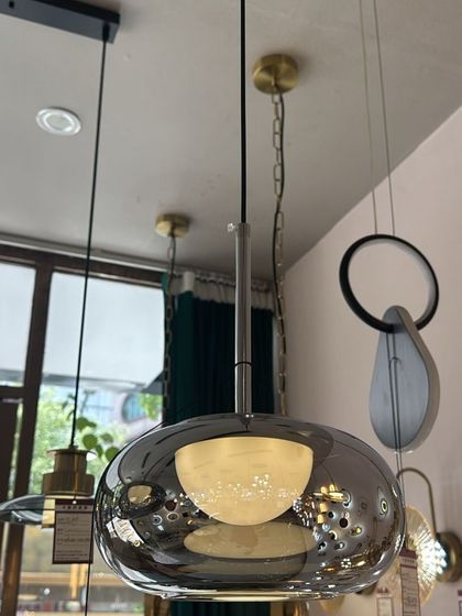 A large pendant with a smoked glass shade and an internal frosted diffuser. This design provides a soft, glare-free light, perfect for a living room.