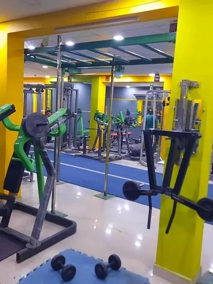 This shot shows the depth of our gym, with various strength machines and the blue turf track in the background. It highlights the different training zones we offer under one roof.