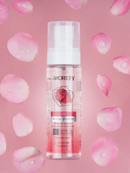 A creative shot of rose water with floating rose petals. This beautiful and artistic visual is perfect for a brand's advertising campaign.