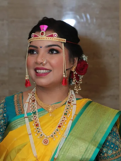 A close-up of a bride in a yellow Nauvari, adorned with a 'bashing' on her forehead for the ceremony.