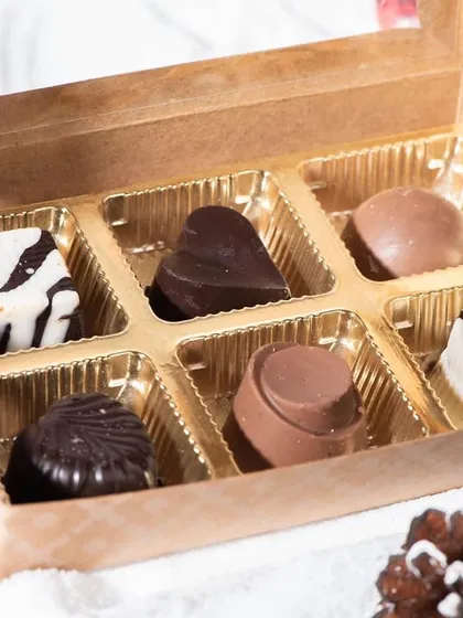 A box of six assorted soft-centered chocolates, perfect for Christmas gifting. The box includes a variety of milk, dark, and white chocolates with different fillings.