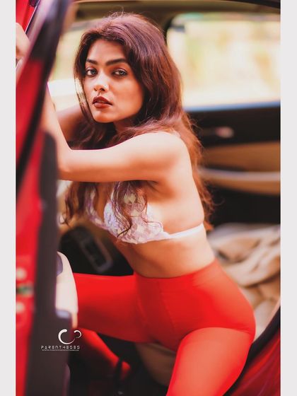 A dynamic and alluring pose, as if stepping out of the car. The composition is full of energy and a sense of daring confidence.