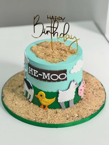 From "HE-MOO" to "Happy Birthday," this adorable farm-themed cake brings the barnyard to the party. It's designed with edible animals, cookie soil, and pastel skies for a sweet countryside twist.
