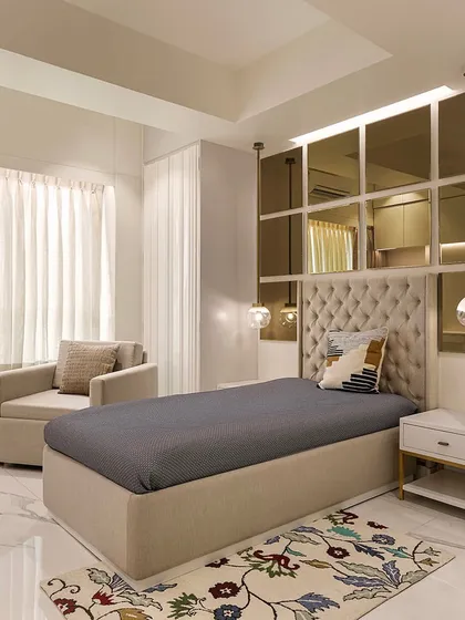 The grandmother's room, though compact, is designed for maximum utility with a single bed and mirrored paneling to visually expand the space.