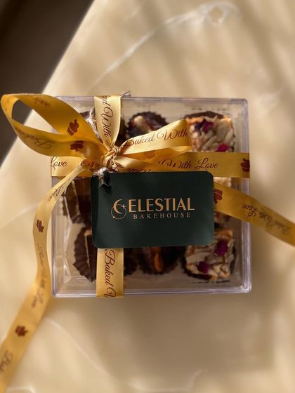 The Celebration Box, elegantly tied with our "Baked with Love" ribbon. This petite box is perfect for any occasion, offering a little something for everyone.
