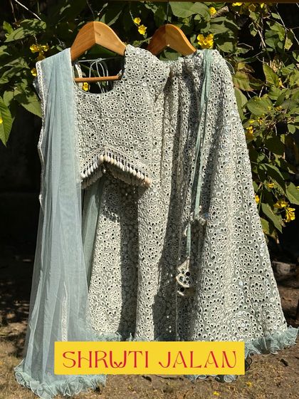 This mint green mirror-work lehenga is a stunning choice for a wedding. The intricate detailing and soft color make it both eye-catching and elegant for any little guest.