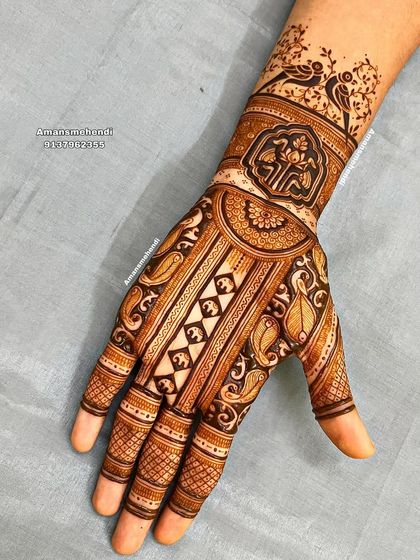 A traditional design featuring birds on a branch at the wrist. The palm is decorated with vertical bands of paisley and geometric patterns.