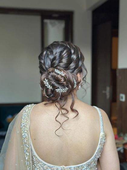 The final messy bun, with soft tendrils left out to frame the face and a beautiful accessory tucked in.
