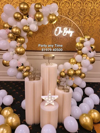 Welcome a new member of the family with an elegant "Oh Baby" shower theme. This beautiful setup features a white and chrome gold balloon arch on a ring frame, an "Oh Baby" neon sign, and matching plinths for gifts and cake.