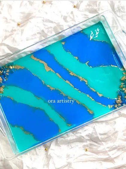 A top-down view of the blue and teal serving tray, showing the beautiful abstract patterns and geode corners.